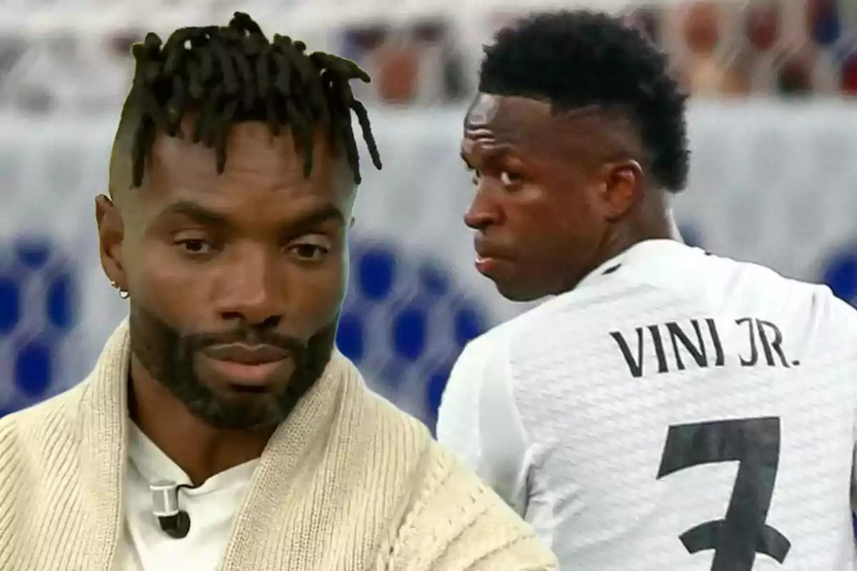 Un hombre con suéter claro y cabello con trenzas está en primer plano mientras un jugador de fútbol con camiseta blanca y el nombre "VINI JR." en la espalda está en el fondo.