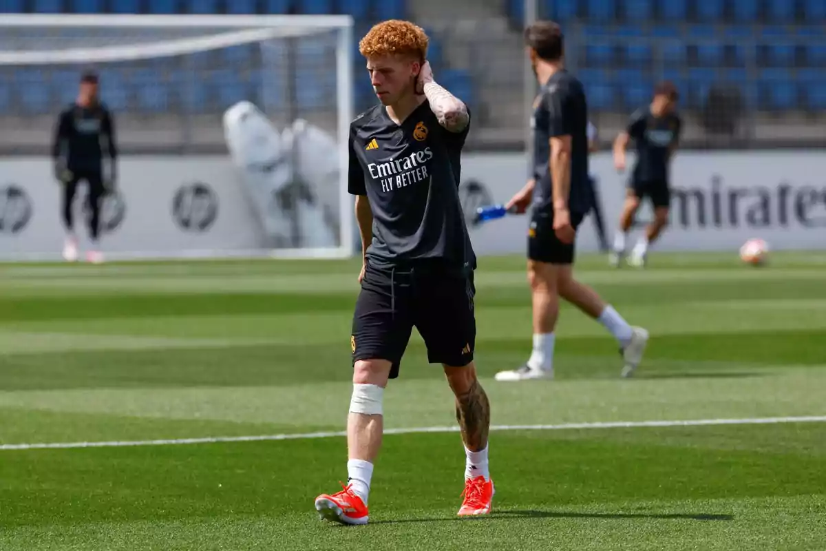 Soccer player in Real Madrid training kit walking on the field with his hand on the back of his neck and a bandage on his left knee Soccer player in Real Madrid training kit walking on the field with his hand on the back of his neck and a bandage on his left knee