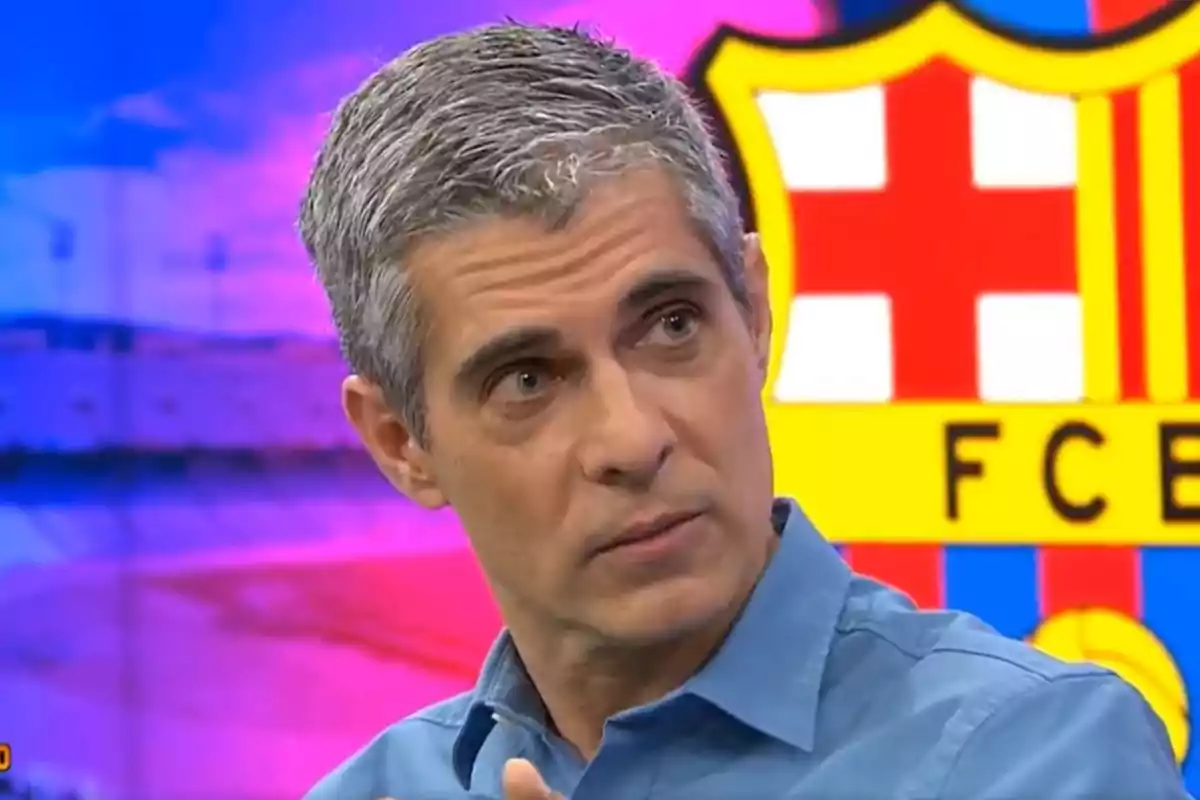 Un hombre de cabello canoso y camisa azul está en un estudio de televisión con el escudo del FC Barcelona de fondo.