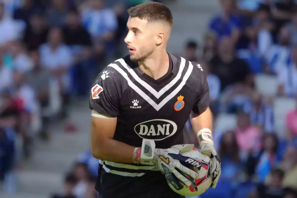 A player in a black uniform and gloves holds a ball in a stadium. A player in a black uniform and gloves holds a ball in a stadium.