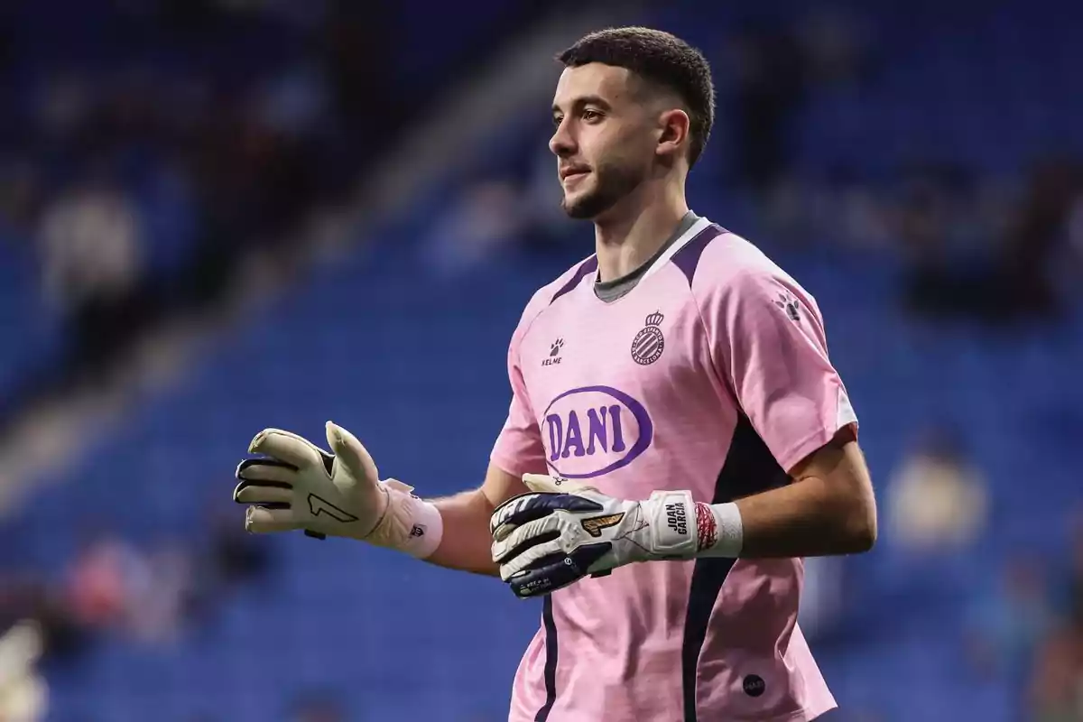 Soccer goalkeeper wearing a pink uniform and white gloves in a stadium Soccer goalkeeper wearing a pink uniform and white gloves in a stadium