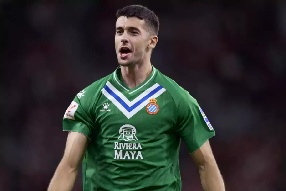 Un jugador de fútbol con uniforme verde celebra en el campo. Un jugador de fútbol con uniforme verde celebra en el campo.