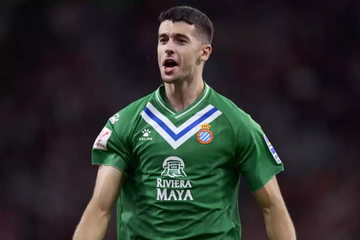 Jugador de fútbol con camiseta verde del RCD Espanyol celebrando en el campo. Jugador de fútbol con camiseta verde del RCD Espanyol celebrando en el campo.