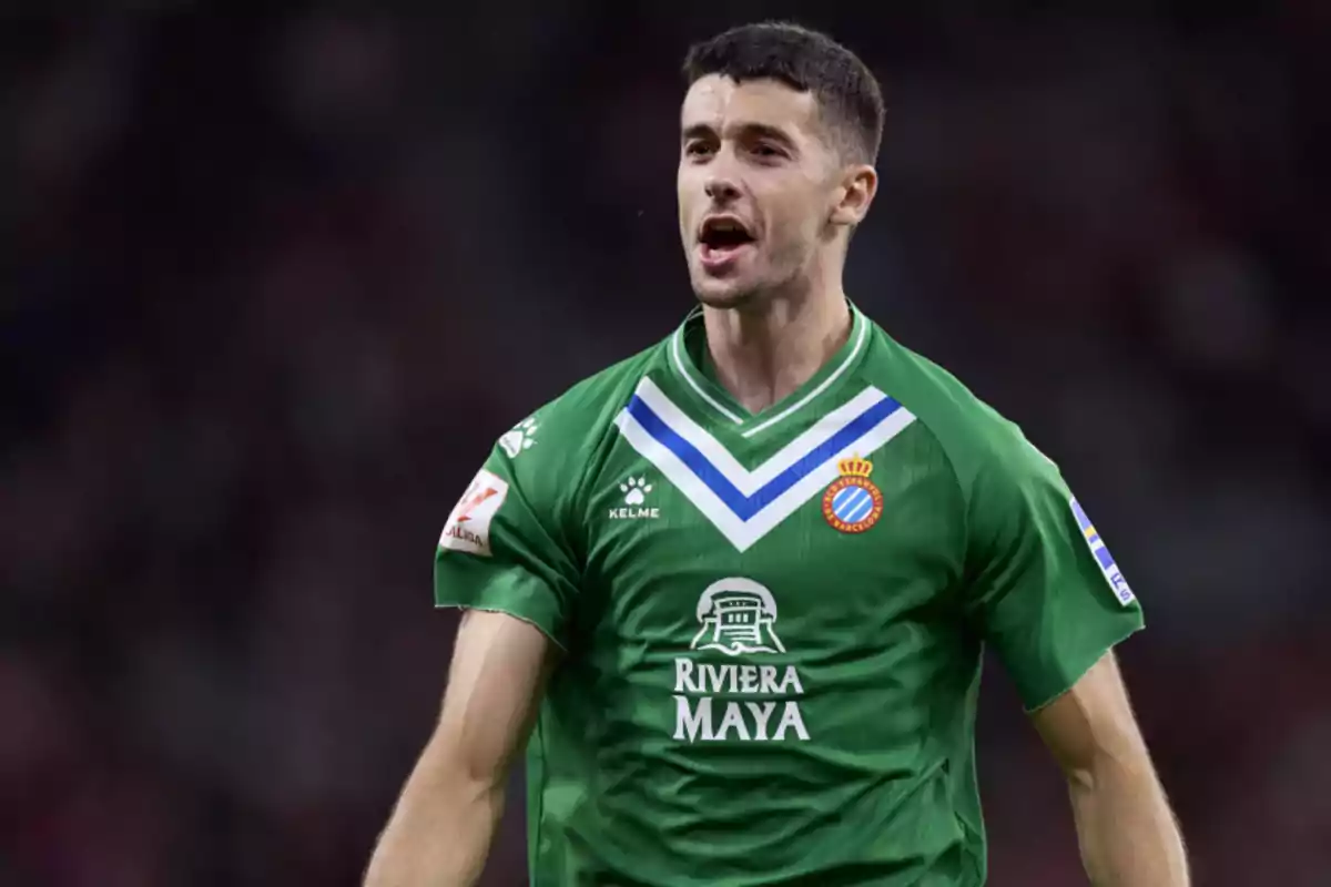 Football player in a green RCD Espanyol jersey celebrating on the field. Football player in a green RCD Espanyol jersey celebrating on the field.