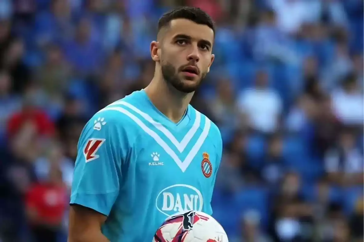 A player in a light blue uniform holds a ball in a stadium full of spectators. A player in a light blue uniform holds a ball in a stadium full of spectators.