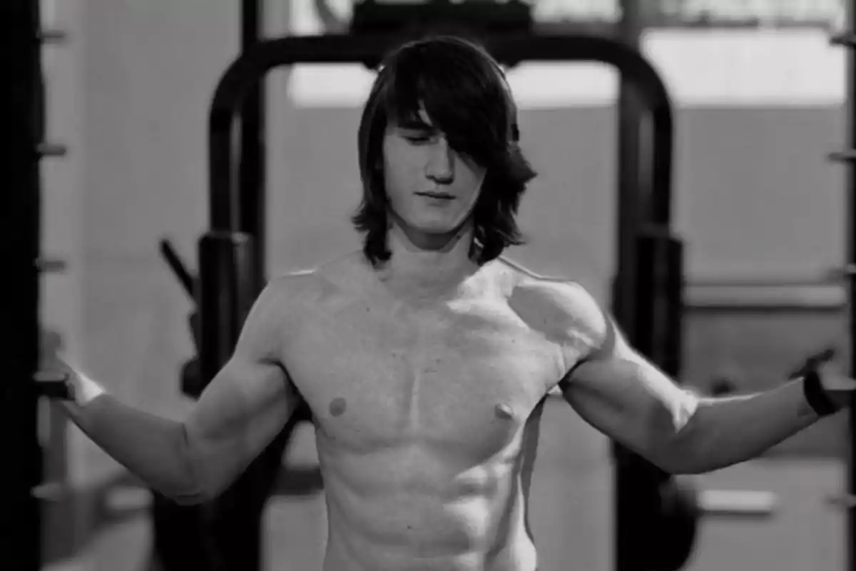 Young man with bare torso and long hair in a gym. Young man with bare torso and long hair in a gym.