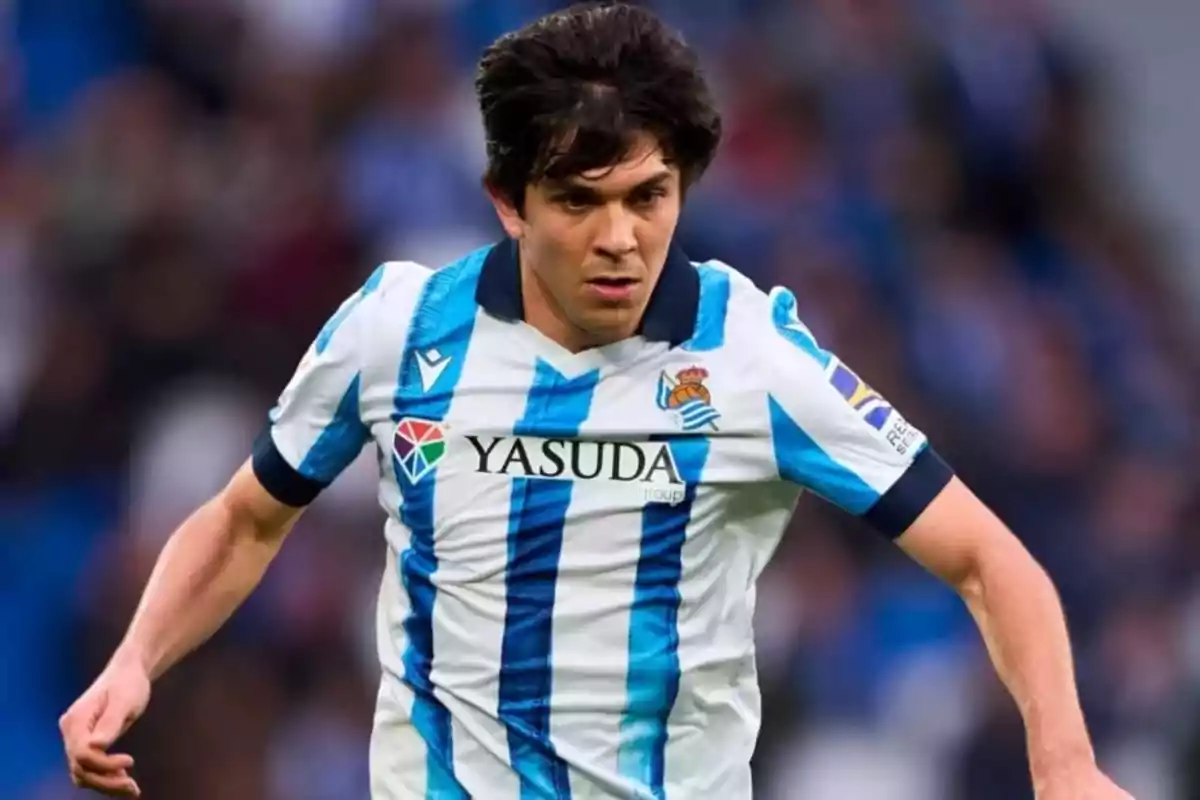 Soccer player in Real Sociedad uniform in action during a match. Soccer player in Real Sociedad uniform in action during a match.