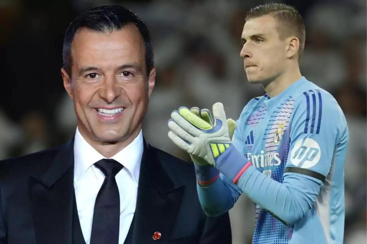 A man in a suit smiles while in the background a soccer goalkeeper in a blue uniform and gloves is clapping.