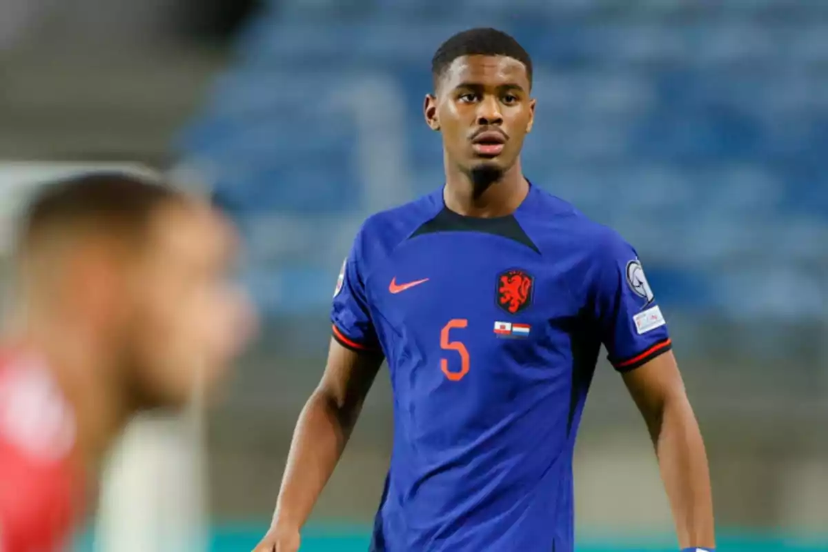 Un jugador de fútbol con el uniforme azul de la selección de Países Bajos en el campo de juego. Un jugador de fútbol con el uniforme azul de la selección de Países Bajos en el campo de juego.