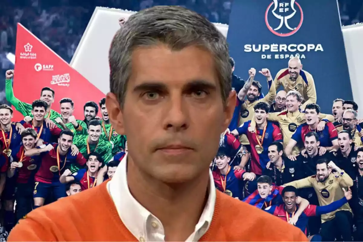 A man in an orange sweater appears in the foreground while a group of soccer players celebrate in the background with the Spanish Super Cup trophy.