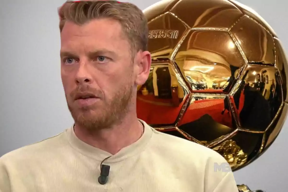 Blond-haired man with a light beard wearing a beige t-jersey and holding a microphone, with a golden Ballon d'Or in the background