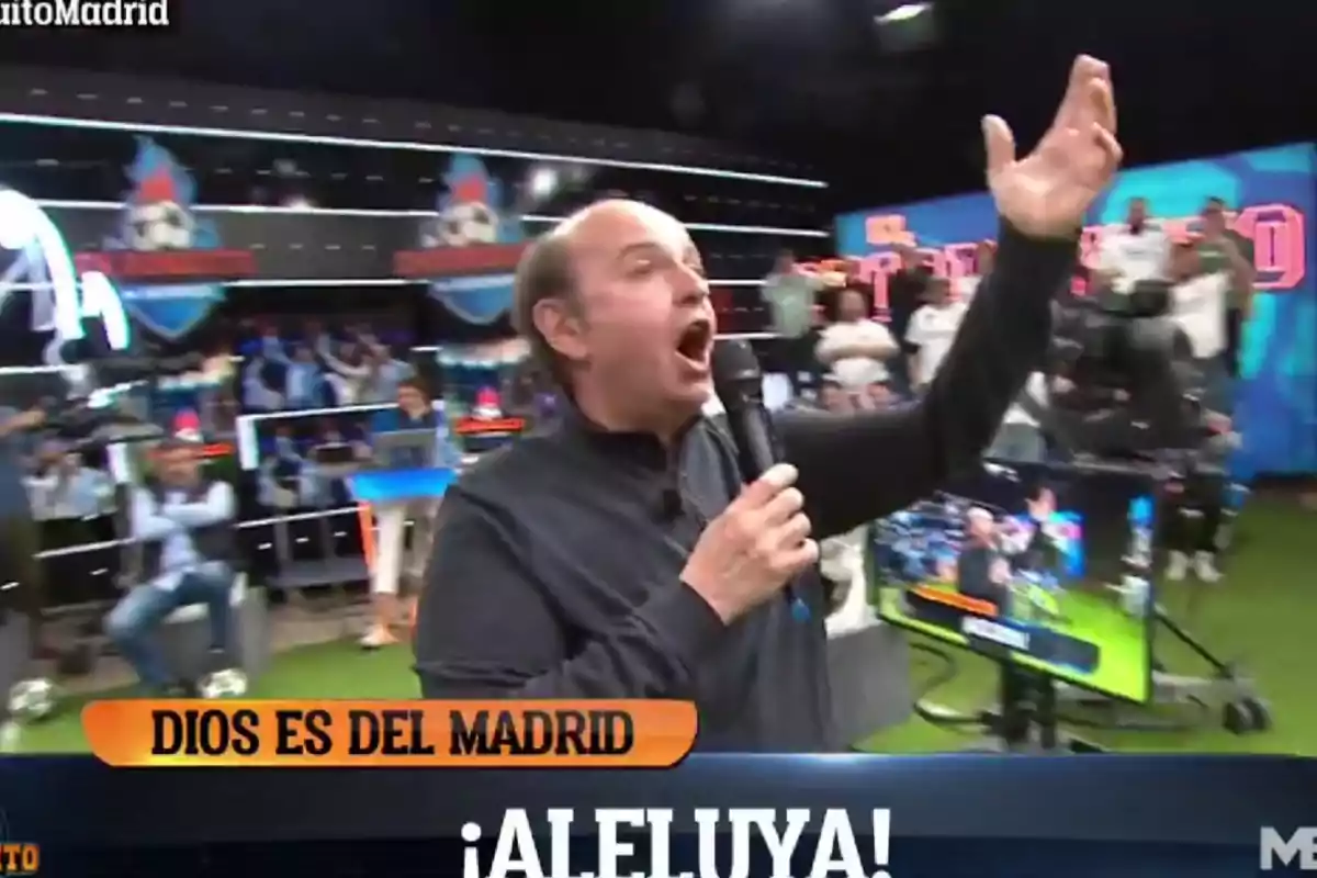 Un hombre en un estudio de televisión sostiene un micrófono y gesticula con entusiasmo mientras en la pantalla se lee "Dios es del Madrid ¡Aleluya!".