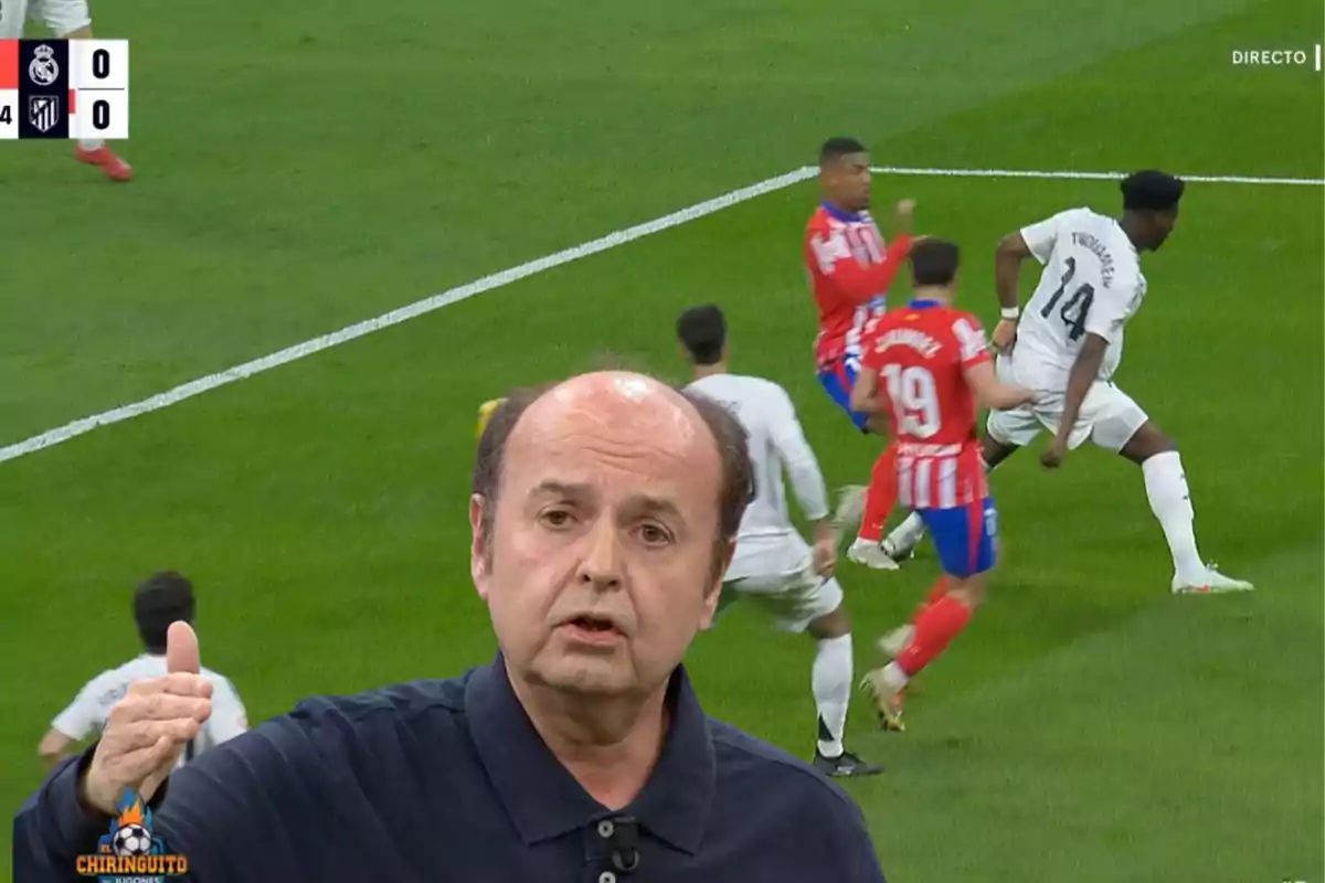 A soccer commentator appears in the foreground while in the background a match is observed between players from teams with white and red uniforms.