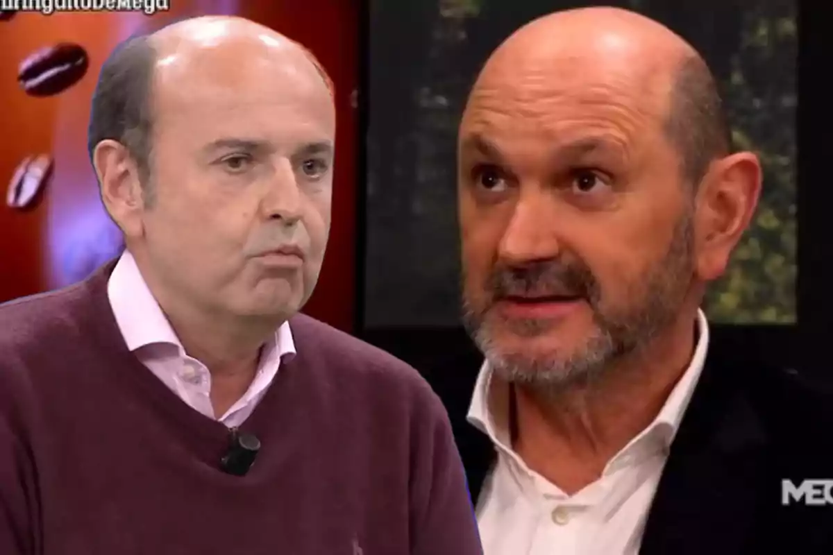 Two bald men with beards and mustaches, one wearing a burgundy sweater and the other a black jacket, appear on a television show with a dark background.