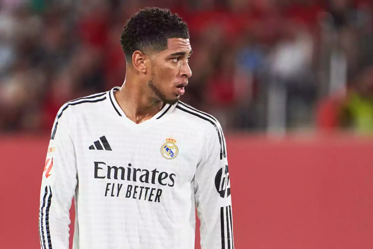 Jugador de fútbol con uniforme blanco del Real Madrid en el campo de juego. Jugador de fútbol con uniforme blanco del Real Madrid en el campo de juego.