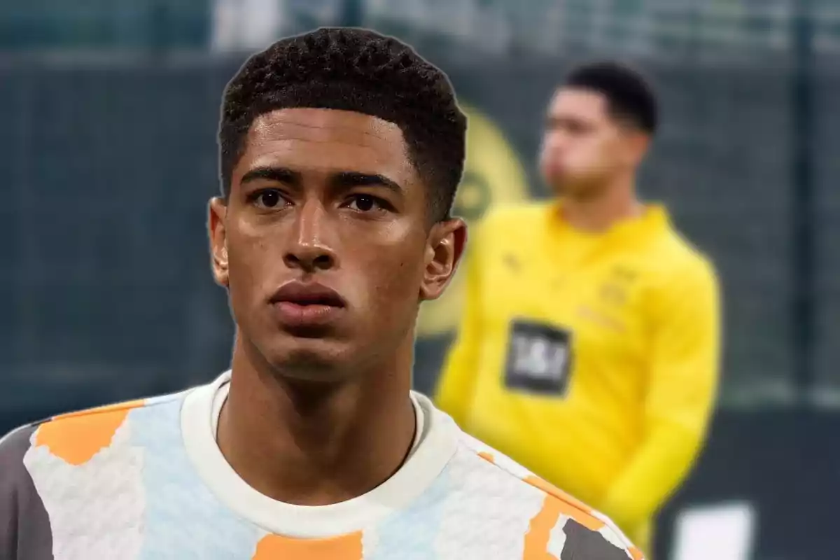 Joven futbolista con expresión seria en primer plano y persona desenfocada al fondo en un entorno deportivo