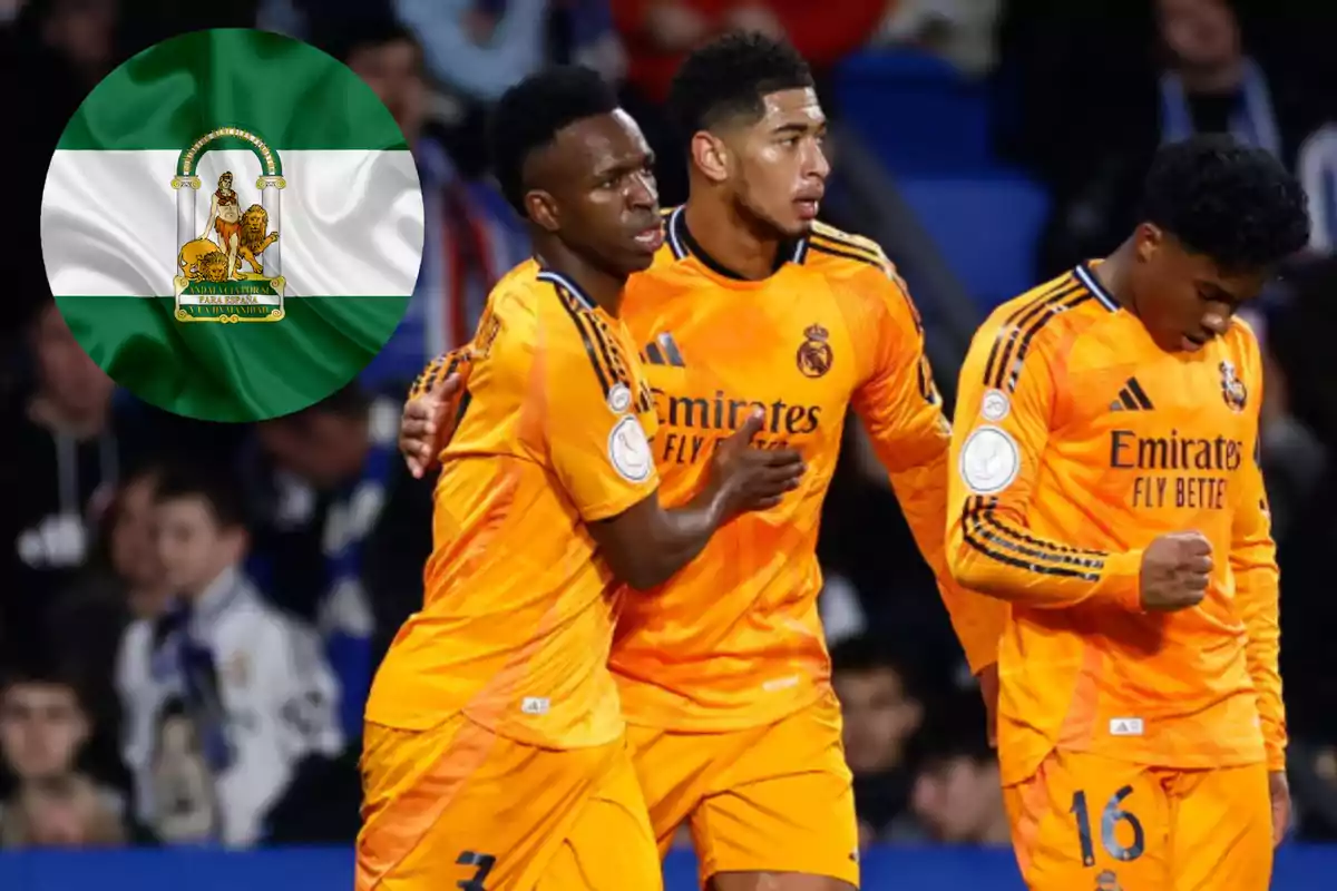 Soccer players in orange uniforms celebrate on the field, with an Andalusian flag in the background.