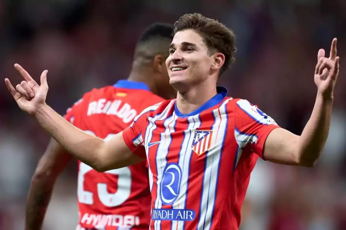 Un jugador de fútbol con uniforme rojo y blanco celebra en el campo. Un jugador de fútbol con uniforme rojo y blanco celebra en el campo.
