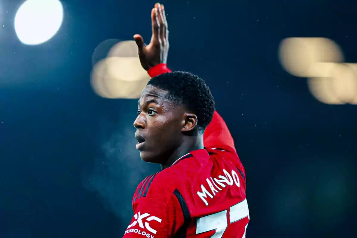 Soccer player in a red uniform raising his hand during a match. Soccer player in a red uniform raising his hand during a match.