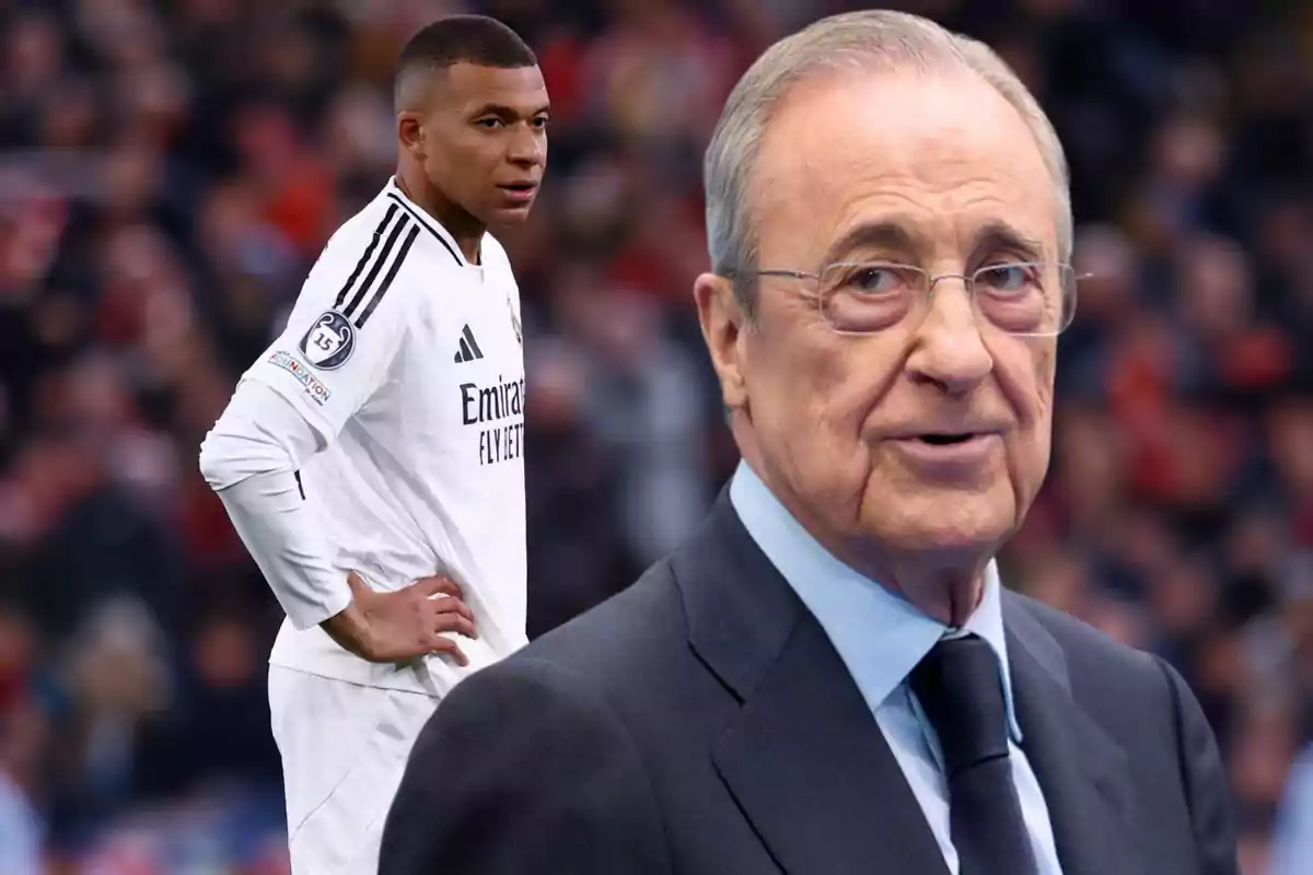 A soccer player in a white uniform stands on the field while an older man in a suit and glasses appears in the foreground.