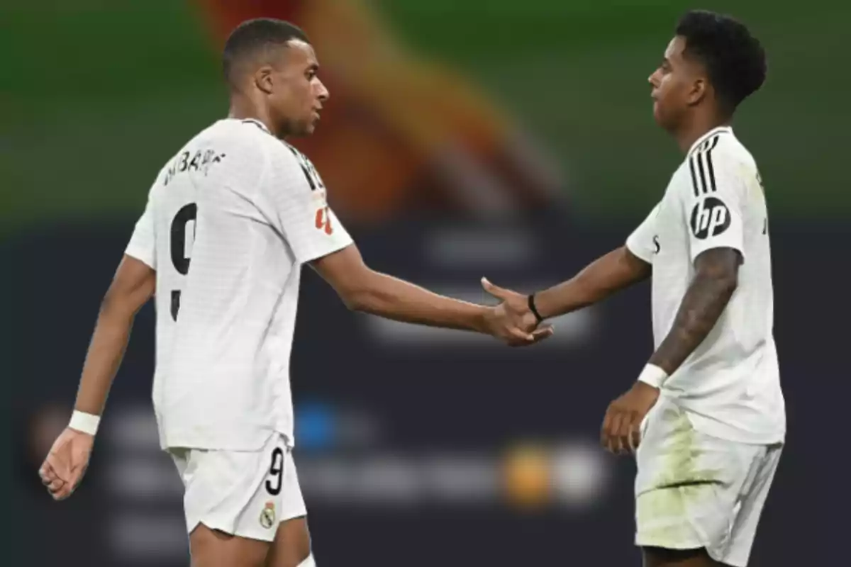 Two players in white uniforms hold hands on the field.