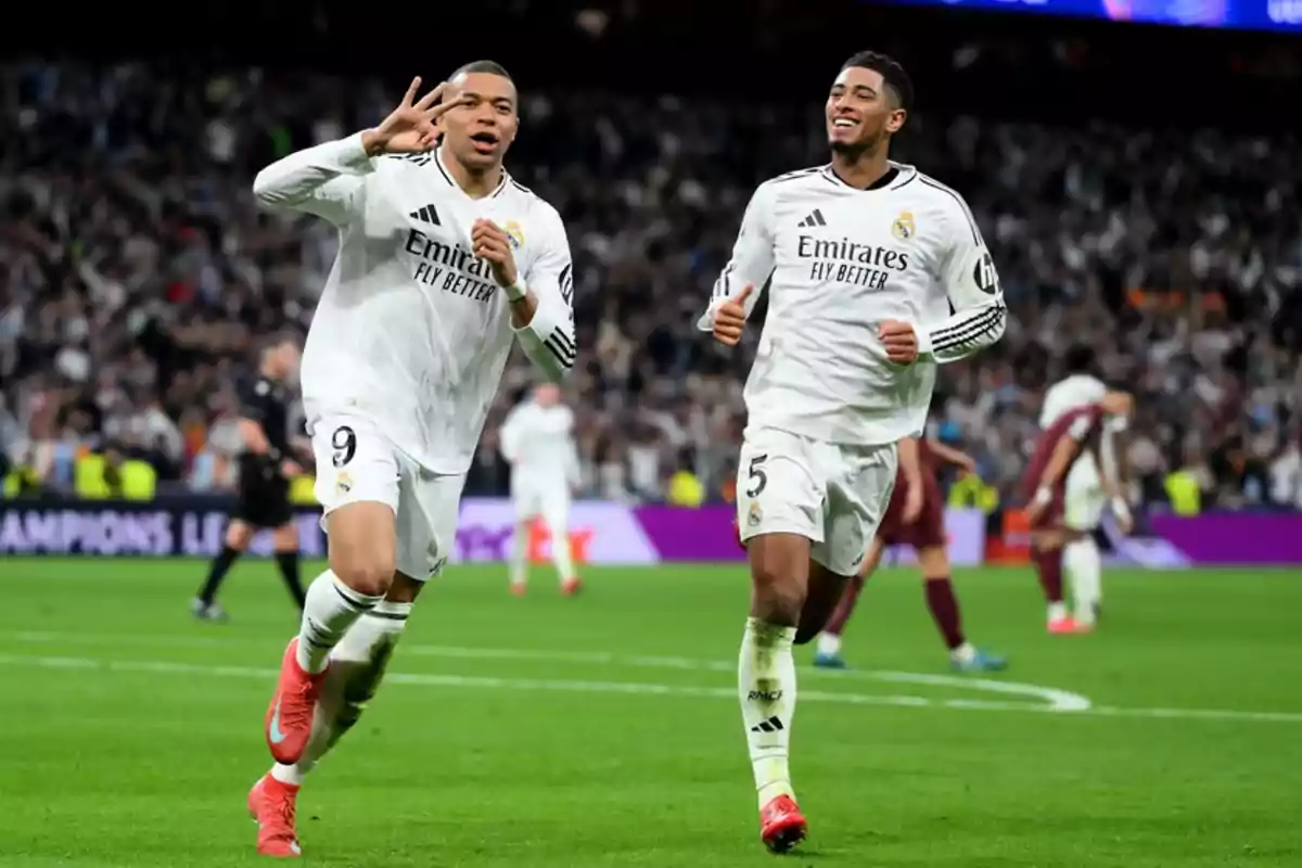 Two Real Madrid players celebrate a goal on the field while the crowd cheers them on.