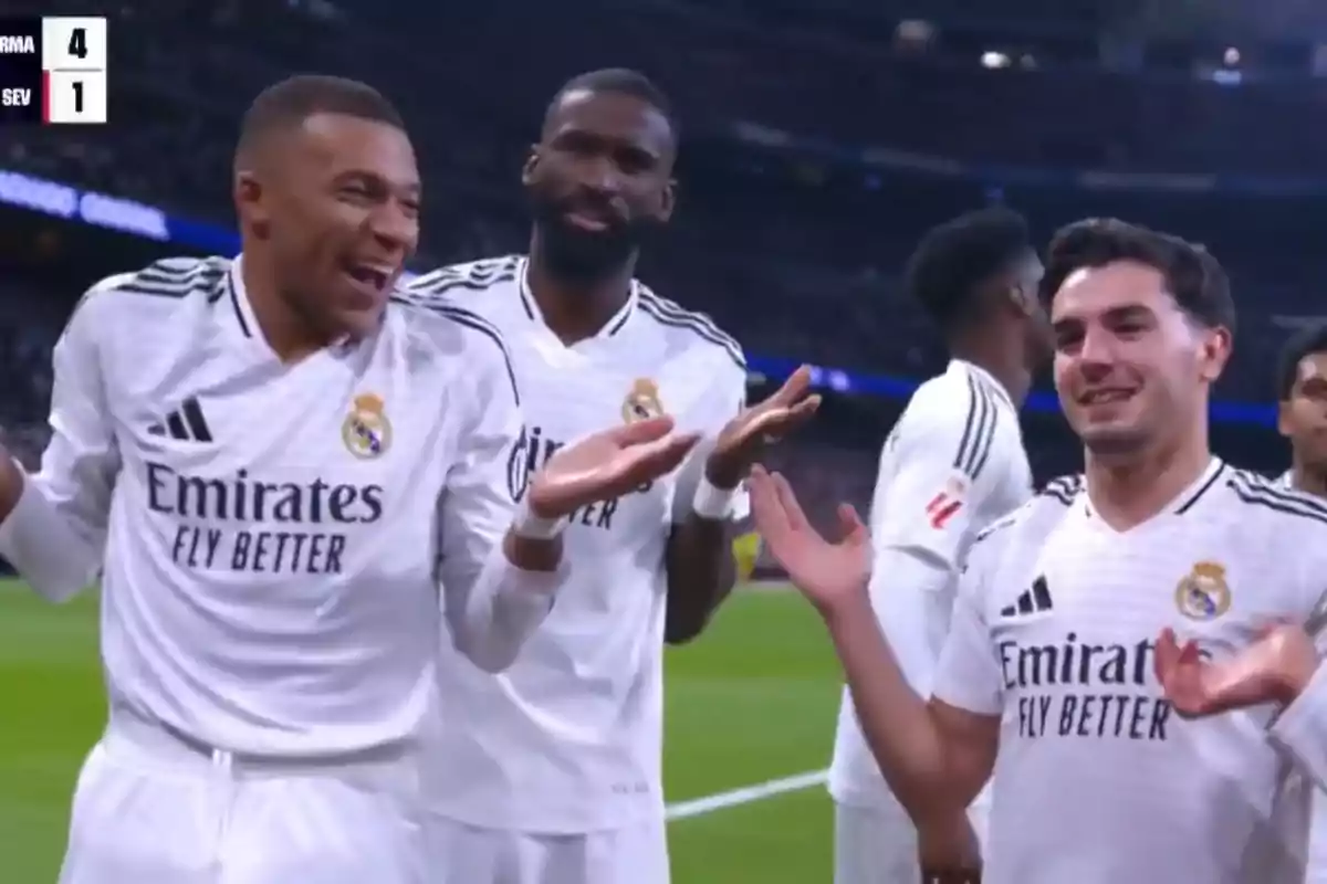 Jugadores de fútbol del Real Madrid celebran en el campo con gestos de alegría y sorpresa, mientras el marcador muestra un resultado de 4 a 1.