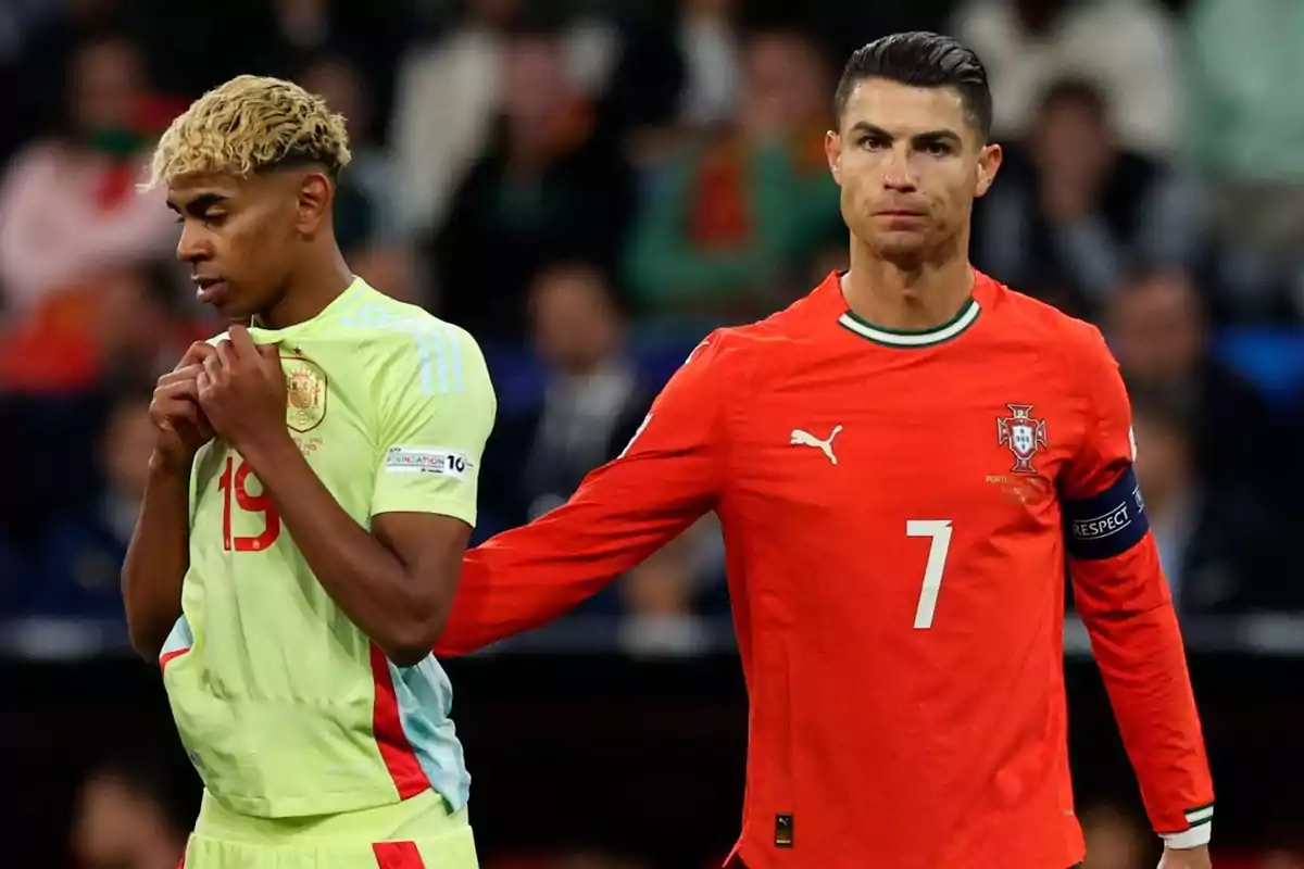 A player from the Spain national team looks thoughtful while a player from the Portugal national team puts his hand on his shoulder during a soccer match.