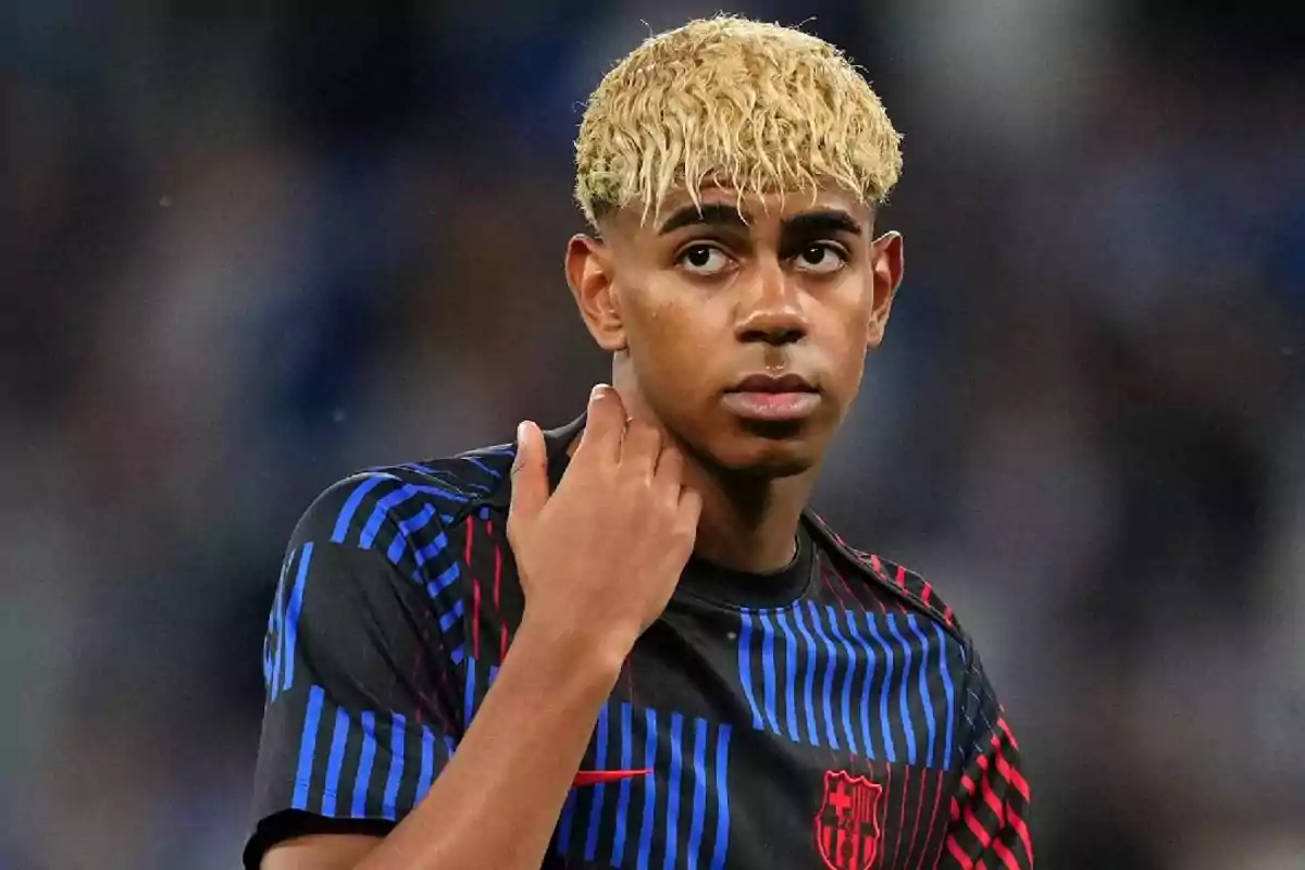 Joven futbolista con cabello rubio rizado usando camiseta de entrenamiento del FC Barcelona Joven futbolista con cabello rubio rizado usando camiseta de entrenamiento del FC Barcelona