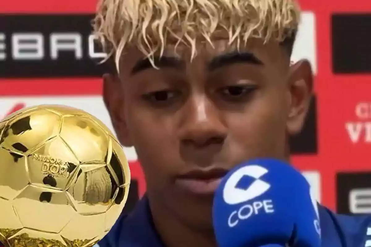 Young blonde curly-haired player at a press conference with a blue microphone and a golden ball in the foreground