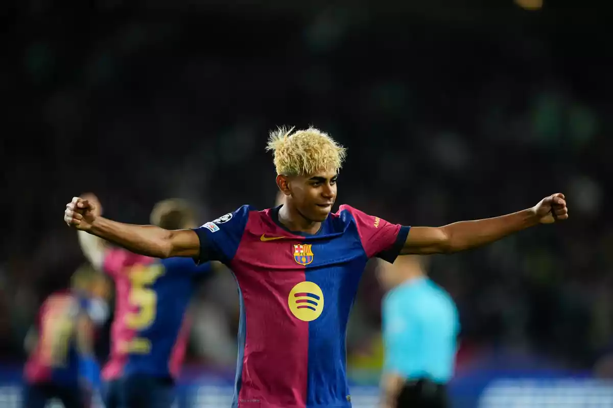 Un jugador de fútbol con el uniforme del FC Barcelona celebra con los brazos extendidos en un estadio. Un jugador de fútbol con el uniforme del FC Barcelona celebra con los brazos extendidos en un estadio.
