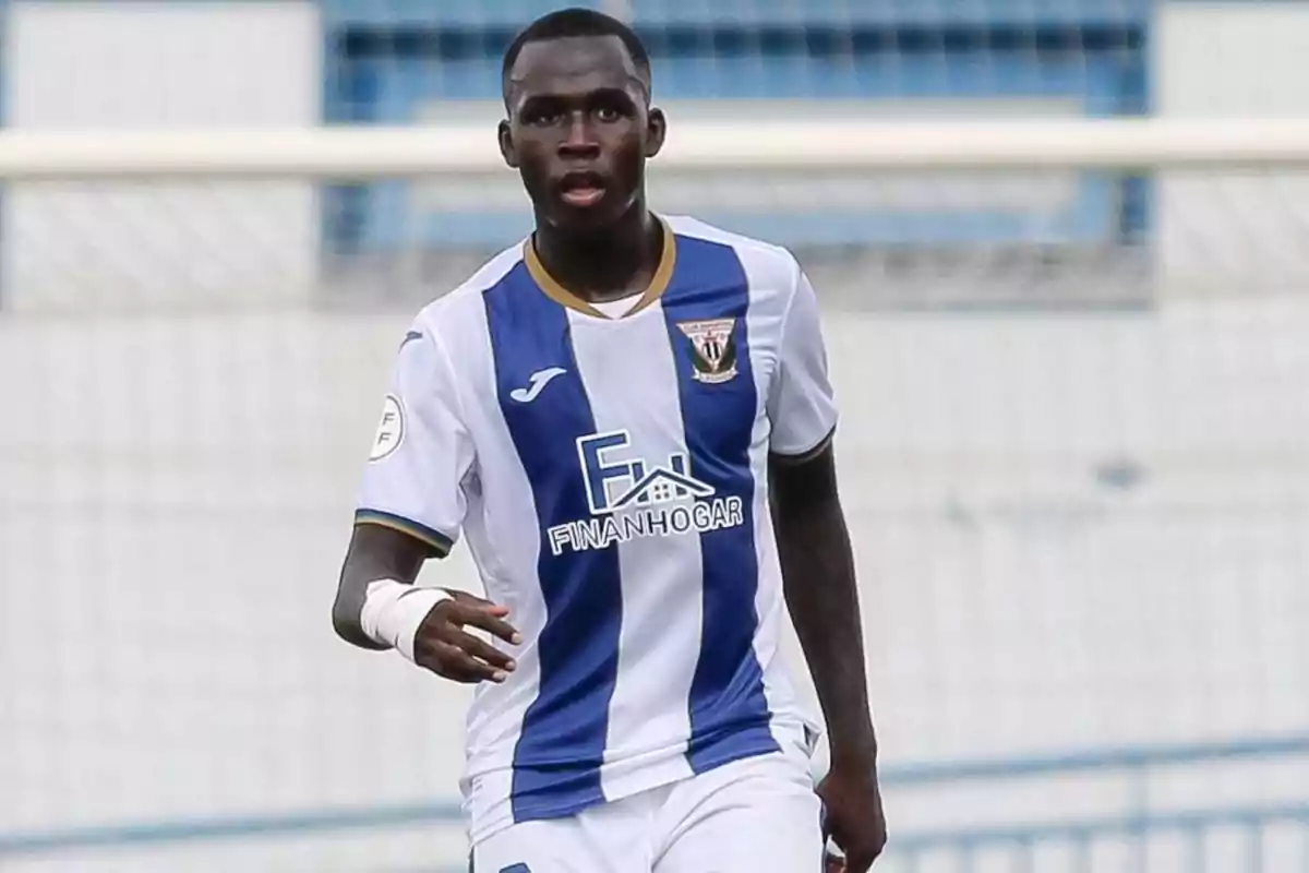 A soccer player in a white and blue uniform on the field. A soccer player in a white and blue uniform on the field.