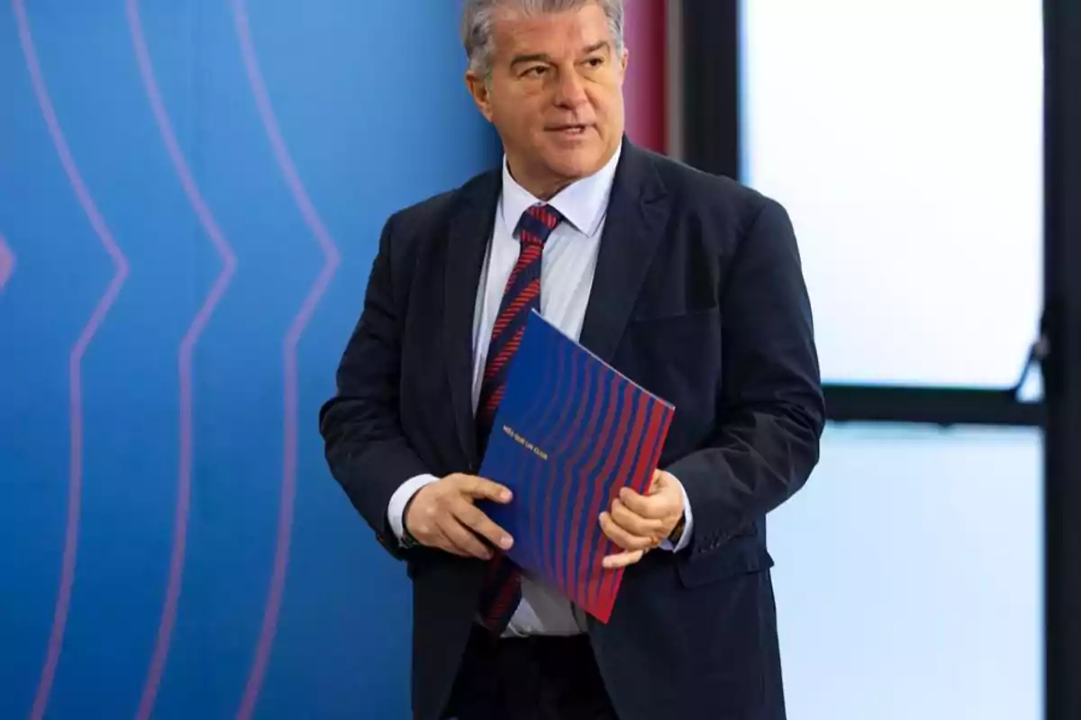 Man in suit holding a blue folder with red stripes in front of a blue background. Man in suit holding a blue folder with red stripes in front of a blue background.