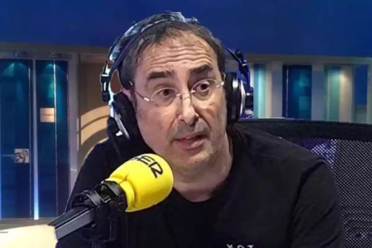 Un hombre con gafas y auriculares habla frente a un micrófono amarillo en un estudio de radio.