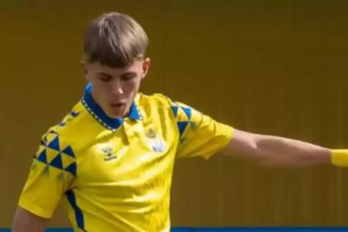 A player in a yellow and blue uniform in action during a match.