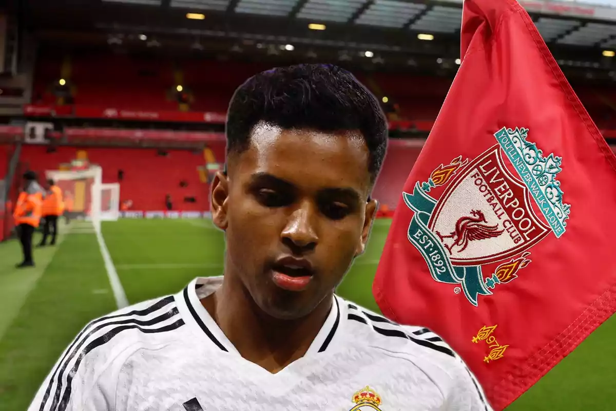 A player in a white jersey is in a stadium with a Liverpool FC flag in the background.