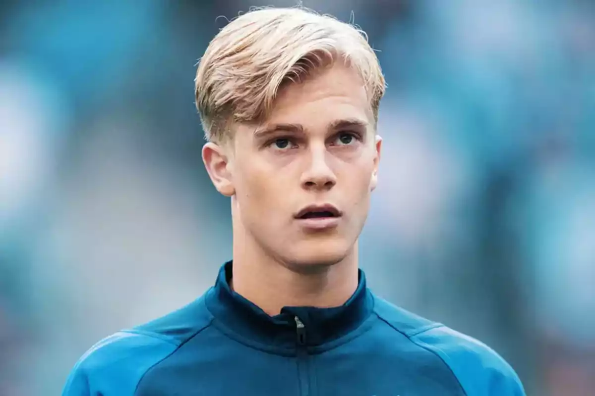 Young man with blonde hair and a blue jacket in a blurred background. Young man with blonde hair and a blue jacket in a blurred background.