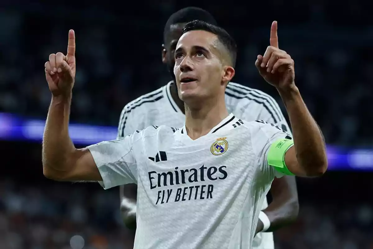 Jugador de fútbol del Real Madrid celebrando un gol con los brazos levantados en el campo.