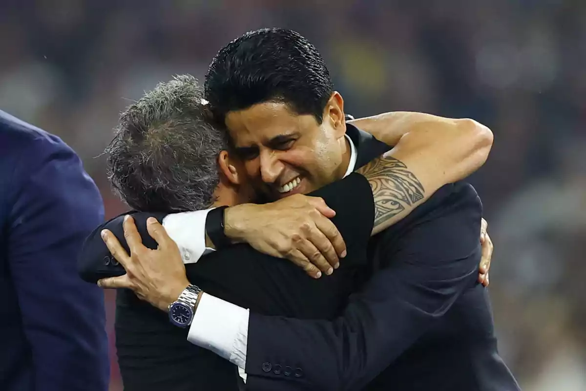 Two men in suits hug each other with smiles in a sports celebration atmosphere. Two men in suits hug each other with smiles in a sports celebration atmosphere.