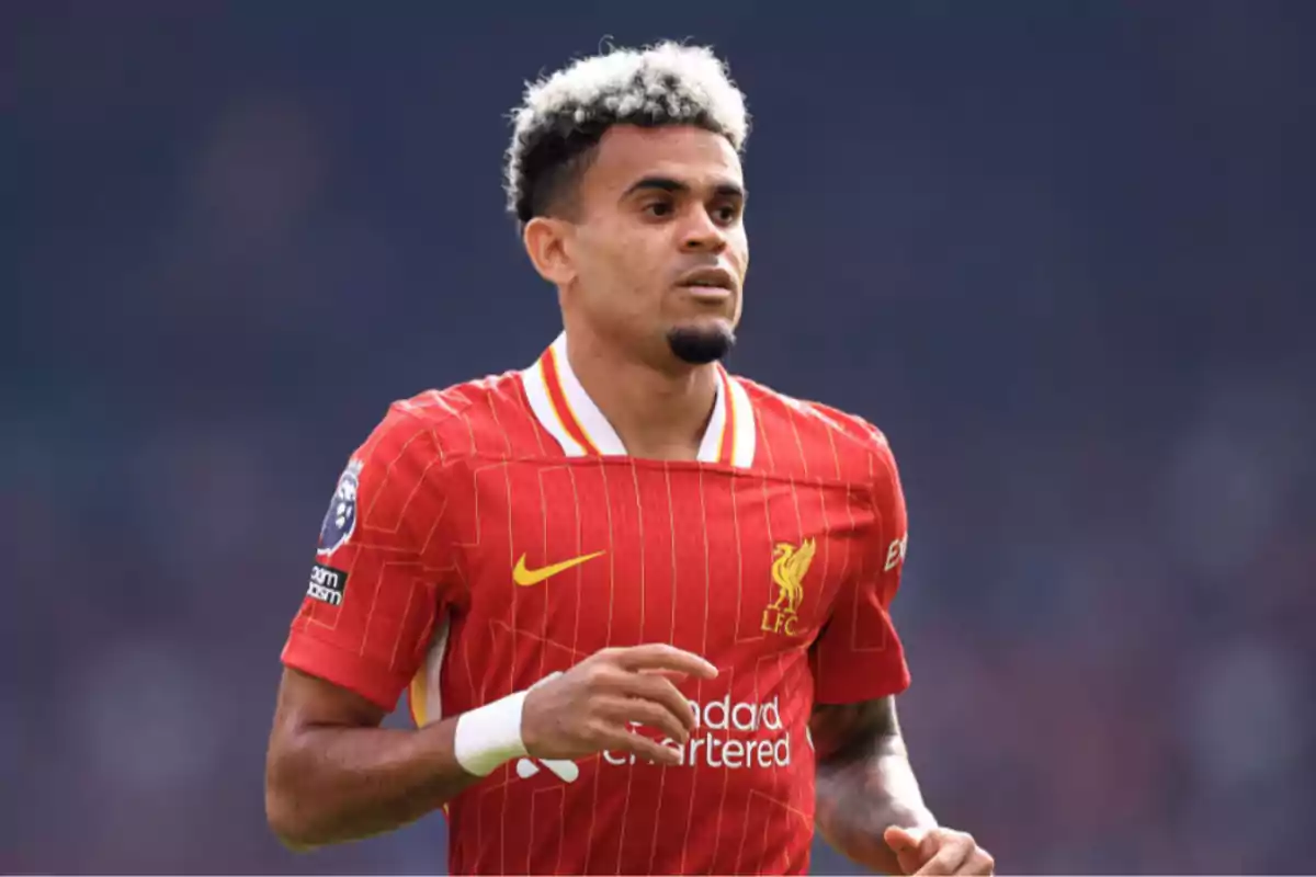 Futbolista con uniforme rojo del Liverpool en el campo de juego Futbolista con uniforme rojo del Liverpool en el campo de juego