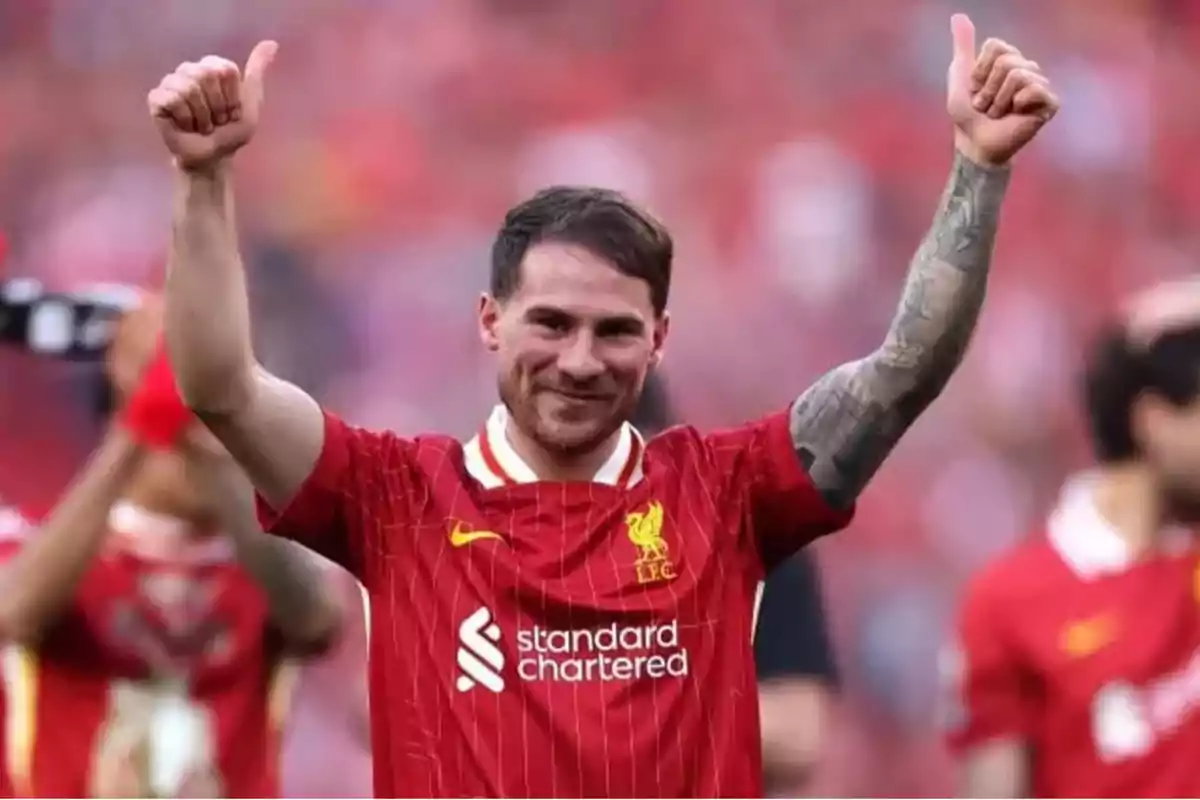 A player in a red uniform gives a thumbs-up in victory at a stadium. A player in a red uniform gives a thumbs-up in victory at a stadium.