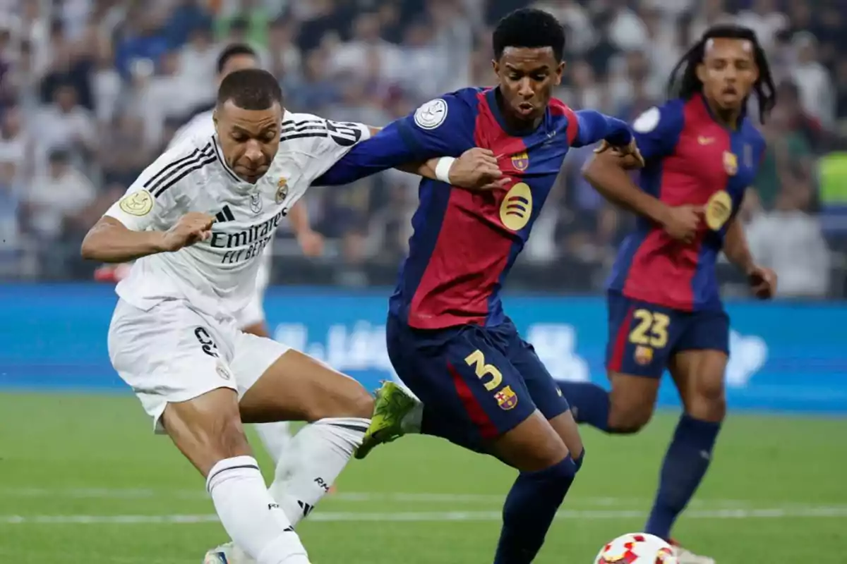 Two soccer players compete for the ball during a match between Real Madrid and Barcelona. Two soccer players compete for the ball during a match between Real Madrid and Barcelona.