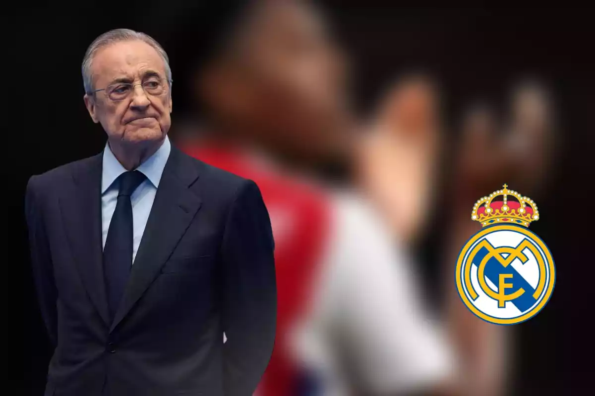 Man in a dark suit with a serious expression and the Real Madrid crest beside him against a blurred background.