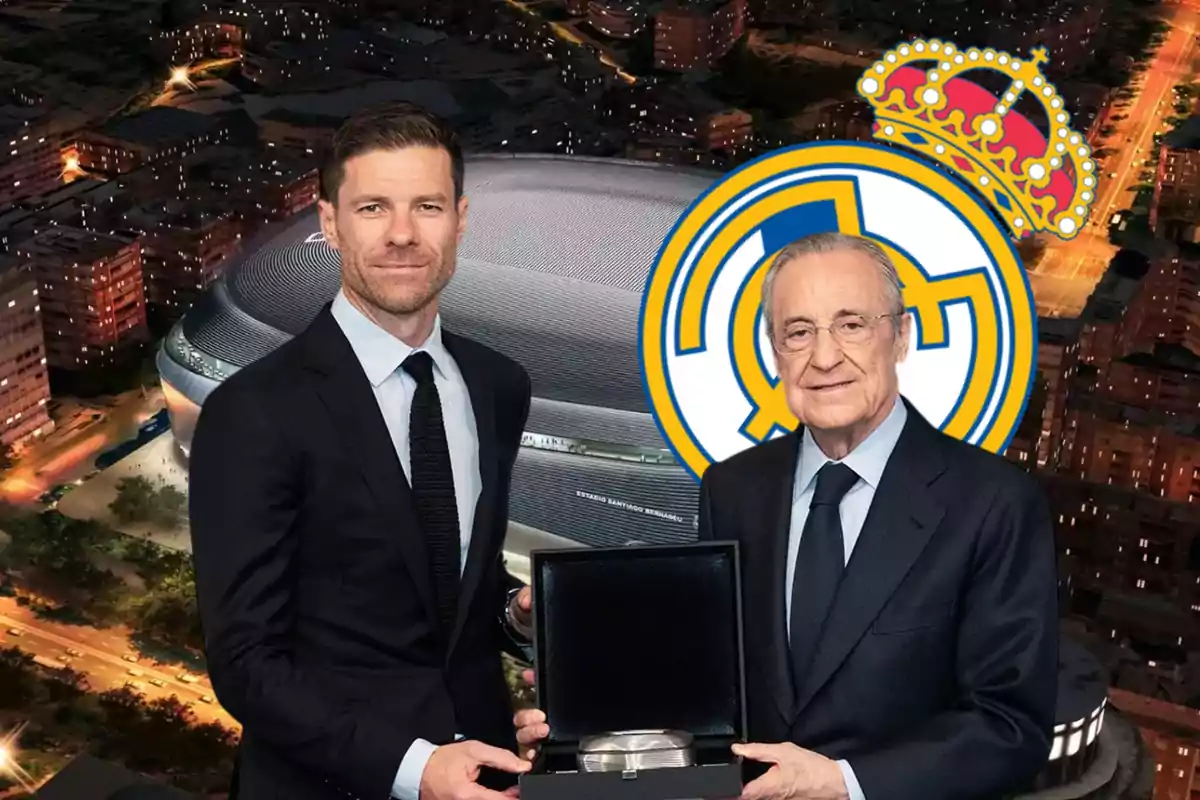 Two men in suits pose in front of Santiago Bernabéu Stadium and the Real Madrid crest; one of them is holding an open box.