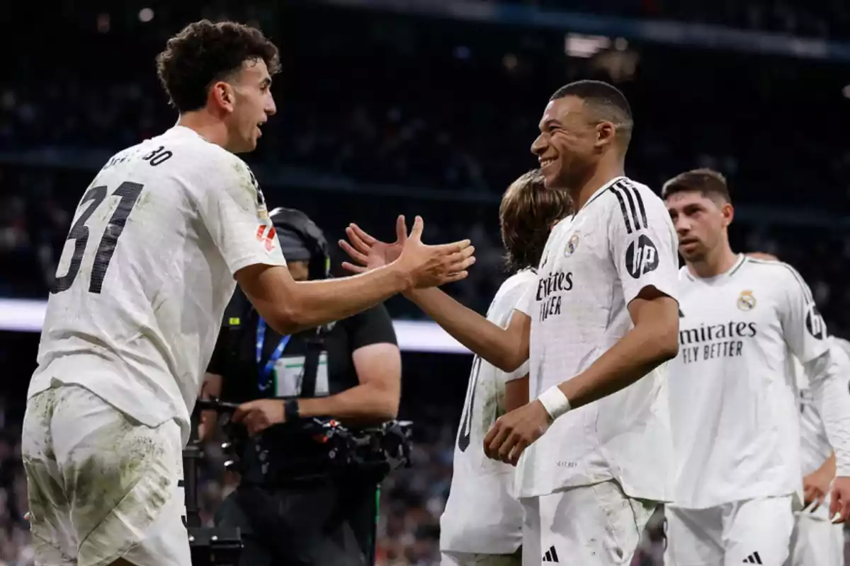 Real Madrid players celebrating on the field with handshakes and smiles.
