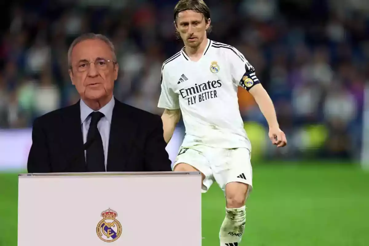 Un hombre de traje habla en un podio con el escudo del Real Madrid mientras un futbolista con uniforme blanco del mismo equipo aparece al fondo en un estadio.