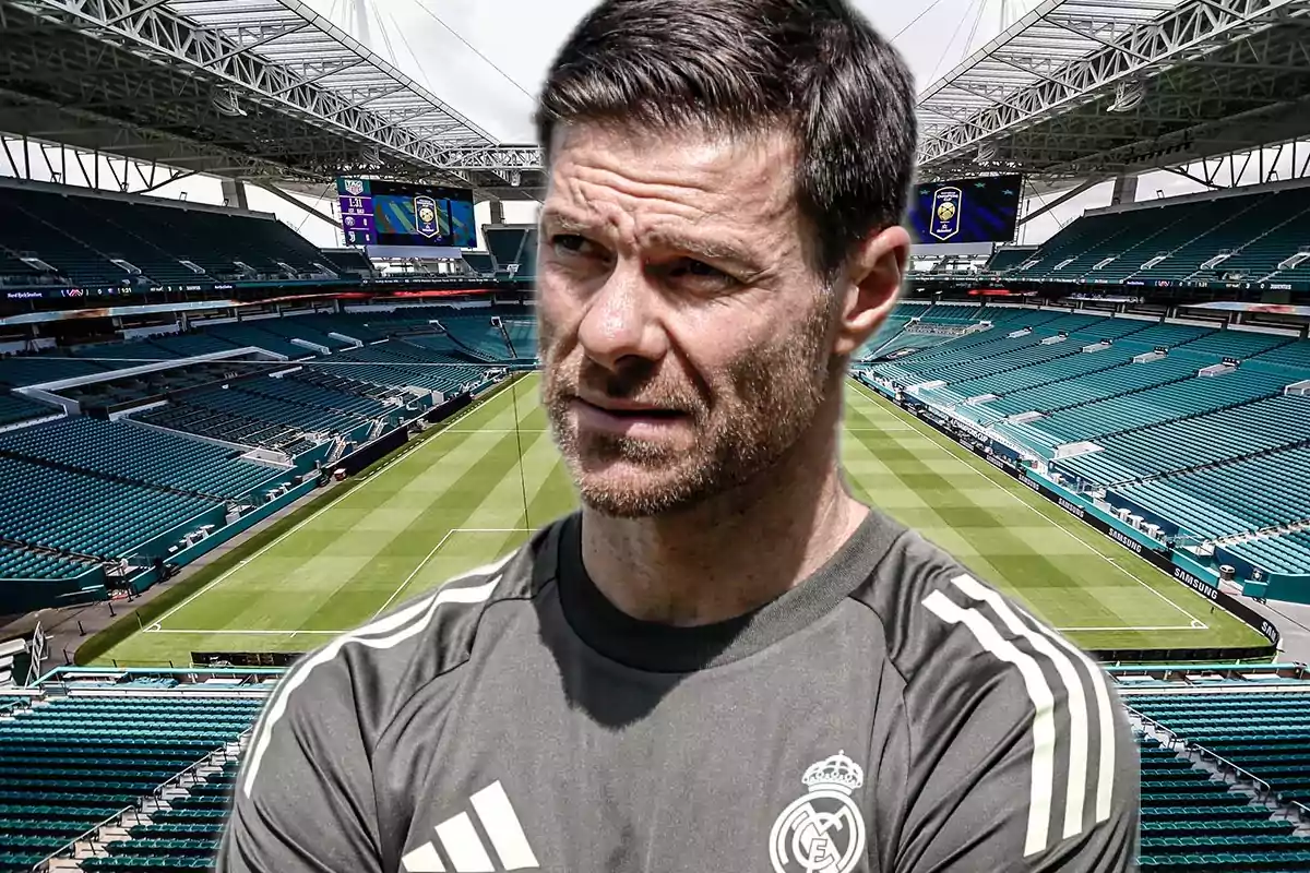Man wearing a Real Madrid training jersey in an empty soccer stadium