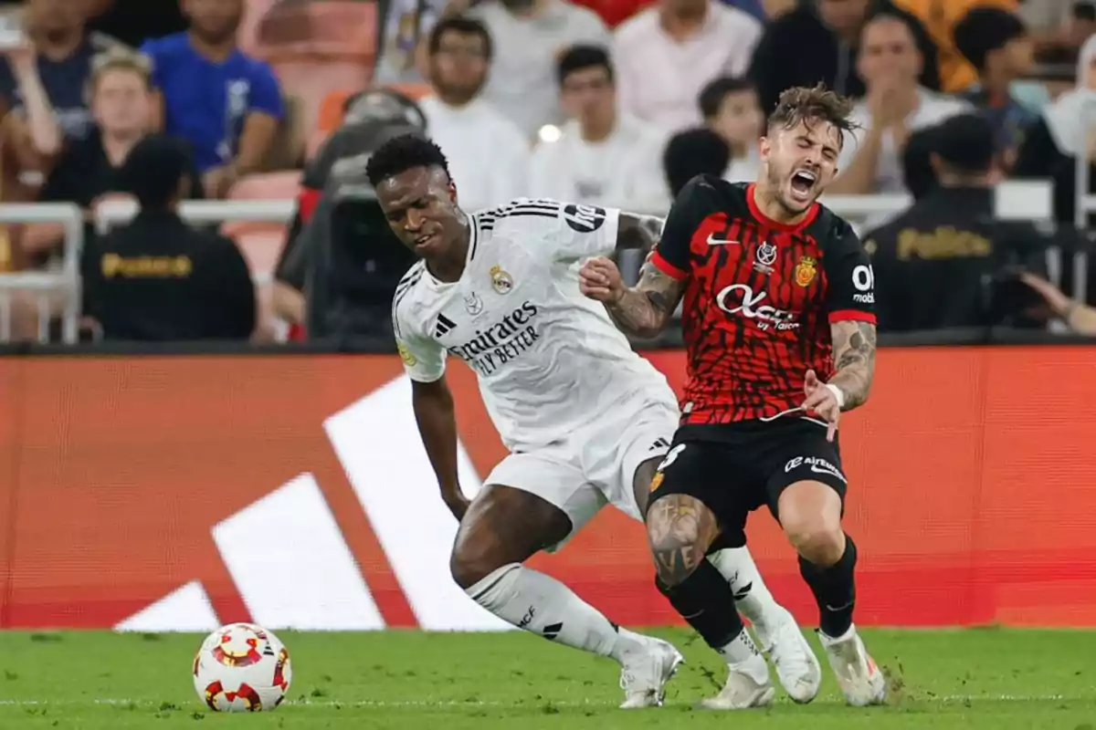 Two soccer players compete for the ball in a game, one of them seems to be falling while the other tries to move forward. Two soccer players compete for the ball in a game, one of them seems to be falling while the other tries to move forward.