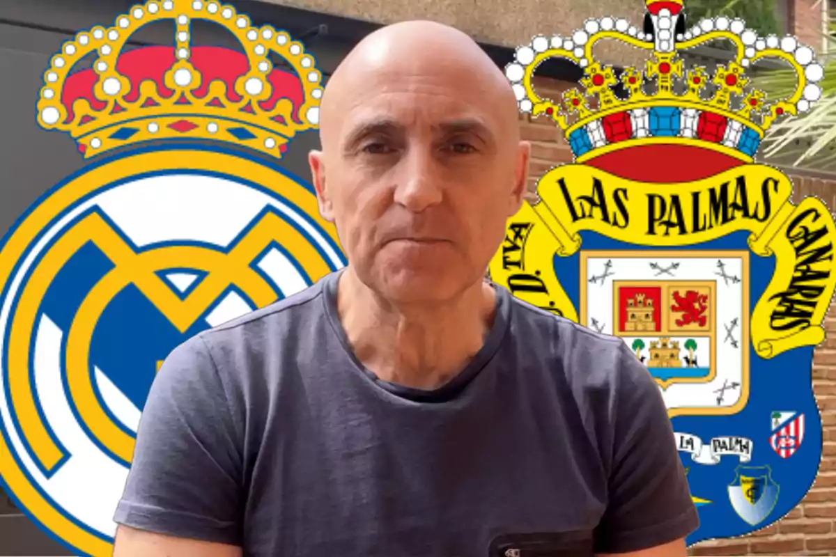 A bald man in a grey T-jersey stands in front of the emblems of the Real Madrid and Las Palmas soccer teams.