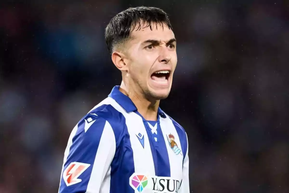 Jugador de fútbol con uniforme a rayas azules y blancas gritando en el campo. Jugador de fútbol con uniforme a rayas azules y blancas gritando en el campo.